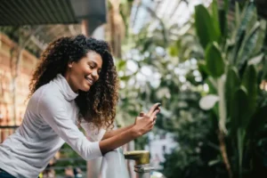 Girl smiling and looking at phone outside of a dental office in Manhattan